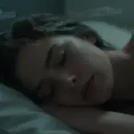 Mujer durmiendo plácidamente con siluetas de cocodrilos translúcidas flotando a su alrededor, evocando un sueño profundo y simbólico.