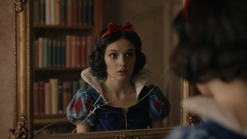Reflejo distorsionado de Blancanieves en un espejo antiguo y agrietado, en una habitación oscura llena de libros.