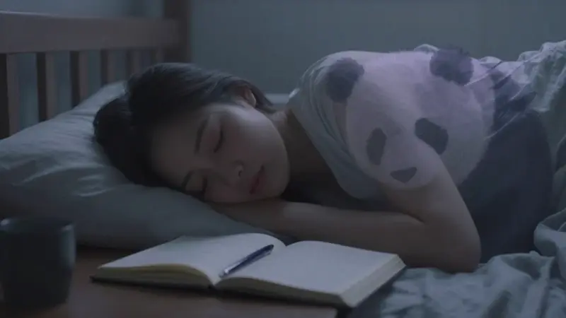 Joven durmiendo en un dormitorio tenuemente iluminado, con la silueta espectral de un oso panda superpuesta, sugiriendo un sueño y la exploración del subconsciente.