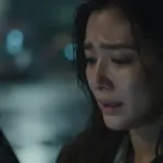 Mujer angustiada en una calle lluviosa y borrosa tras el robo de su celular.